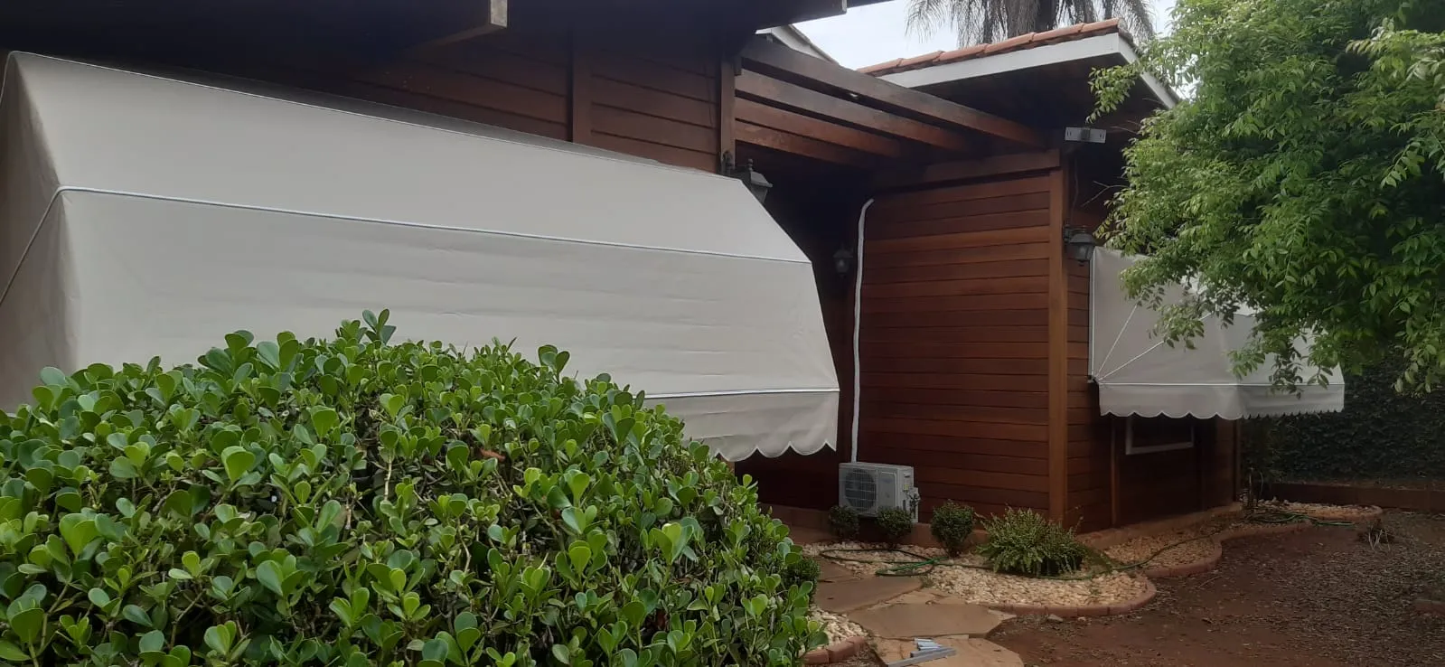 Toldo Mediterrâneo bege com piscina e guarda-sol ao fundo