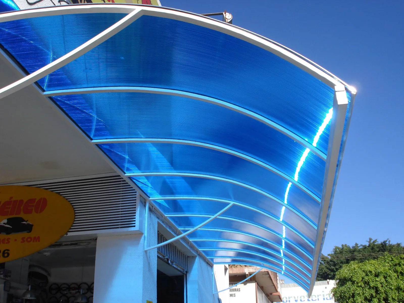 Cobertura de policarbonato azul em fachada comercial