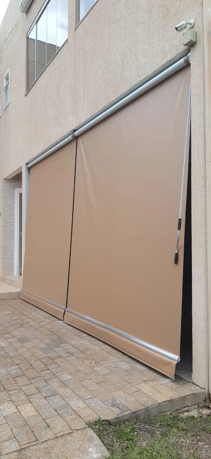 Detalhe do rolo de acionamento de um toldo cortina