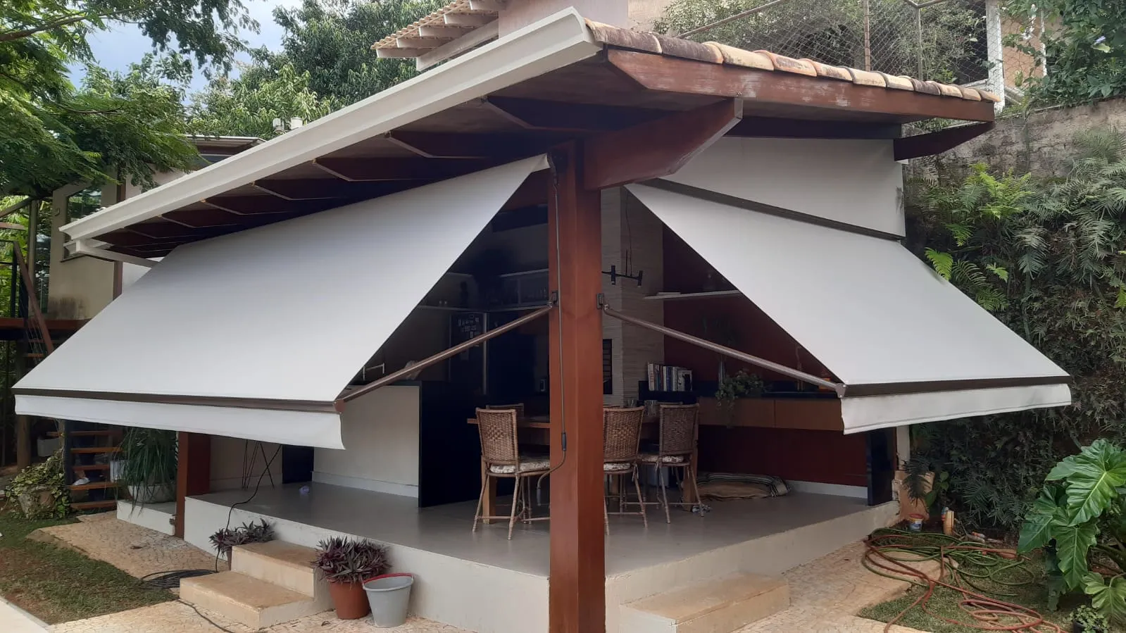 Dois toldos cortina abertos simetricamente em gazebo