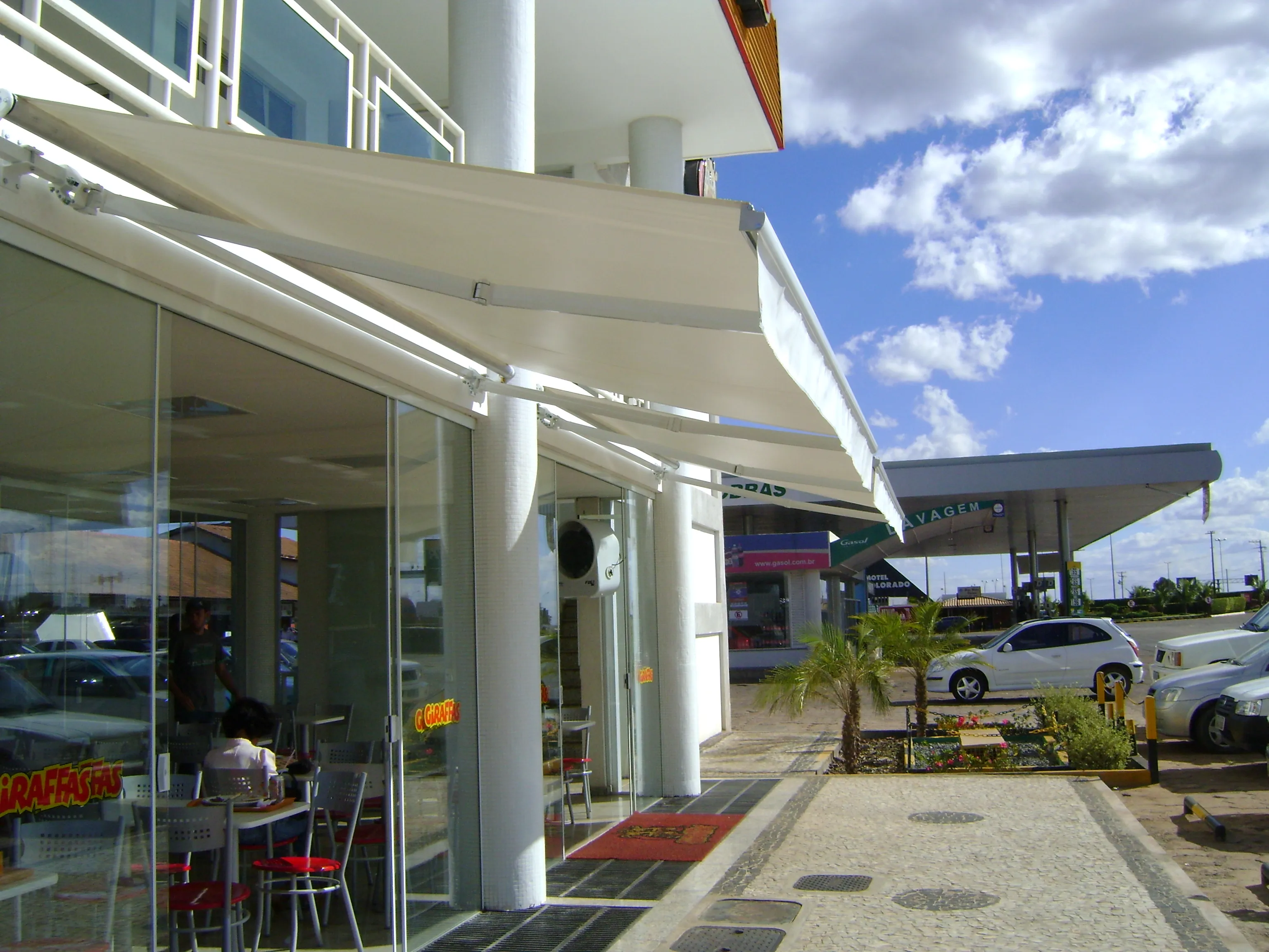 Toldo italiano articulado em fachada de restaurante