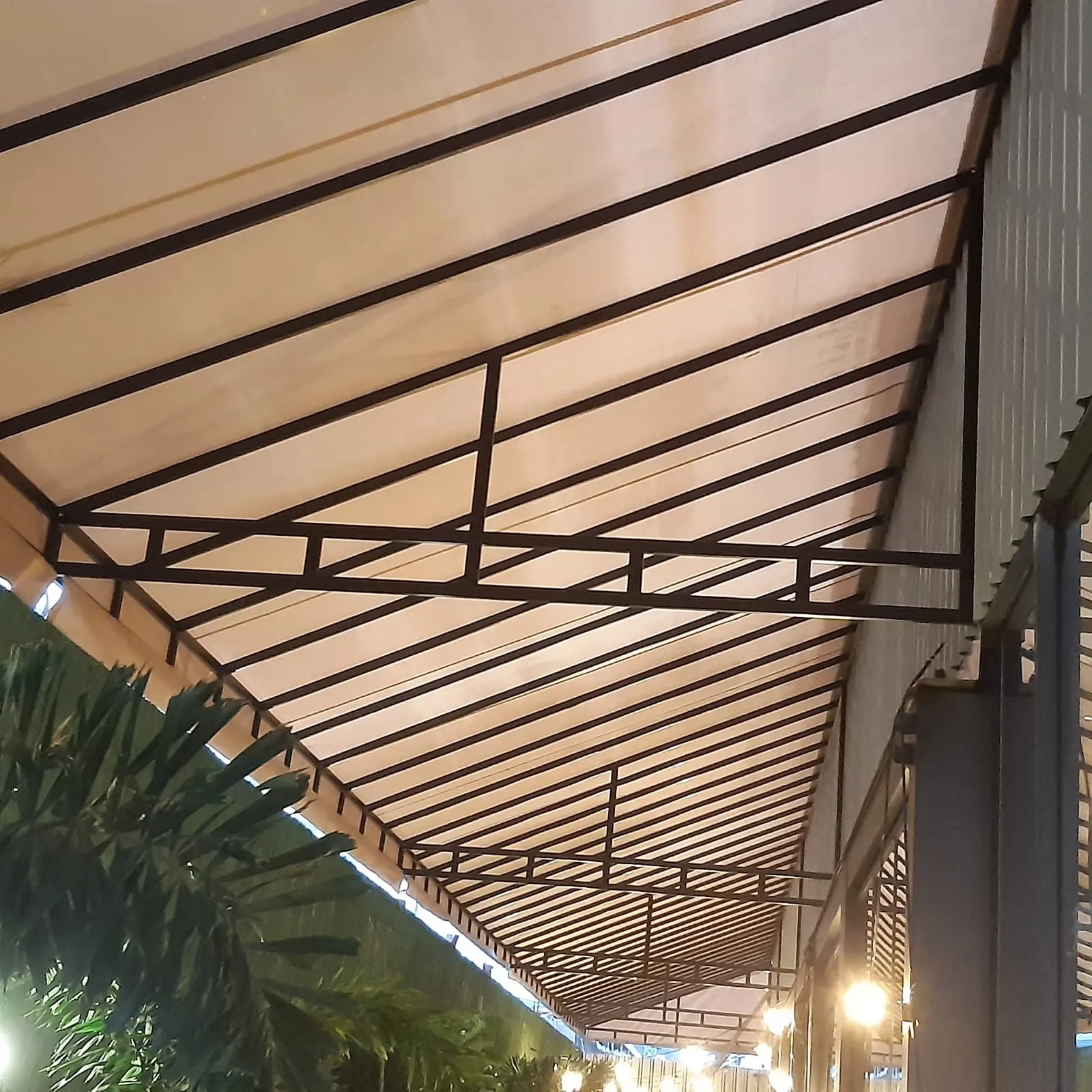 Cobertura fixa em lona em área de restaurante à noite