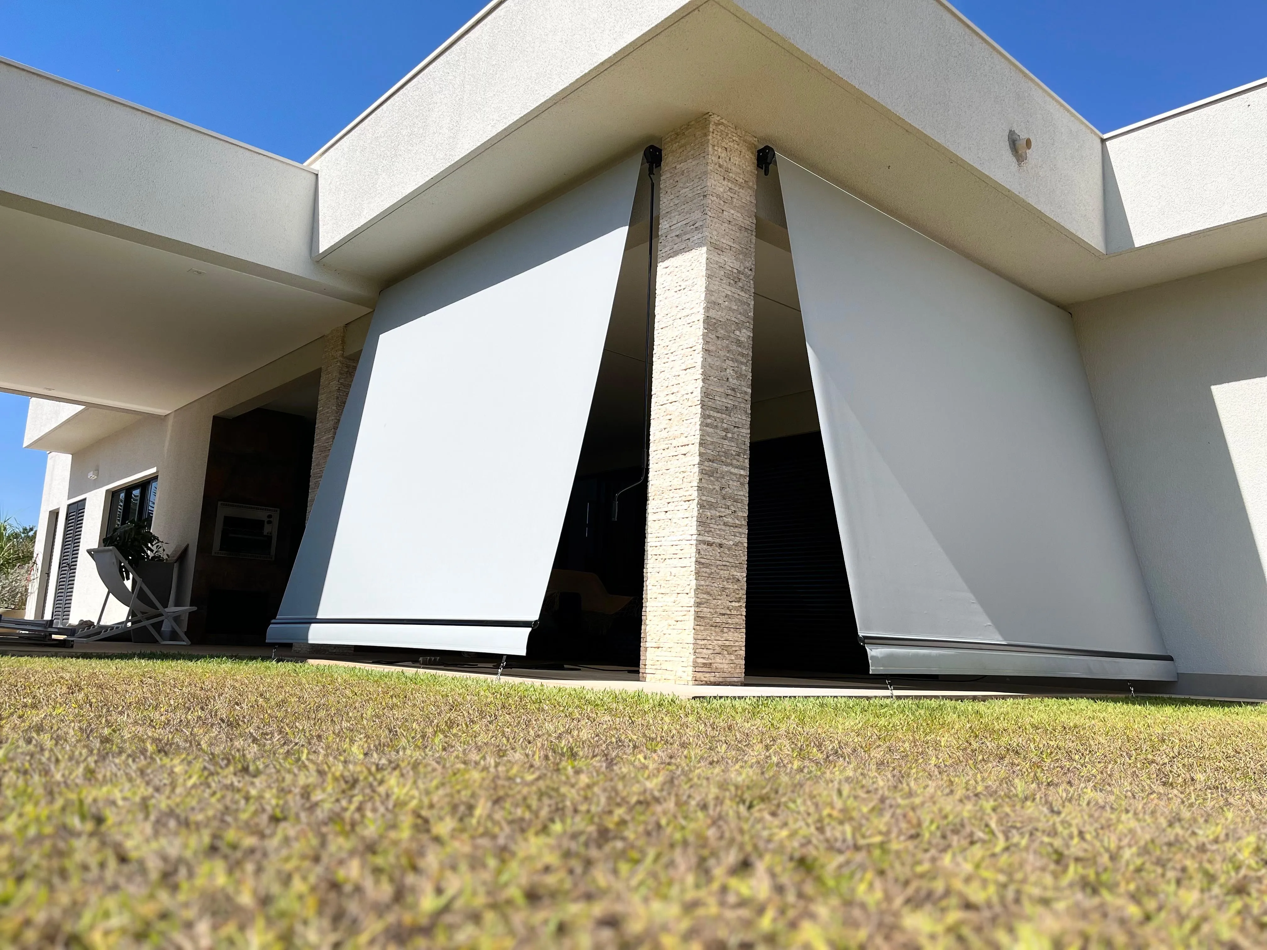 Dois toldos cortina abertos em casa moderna