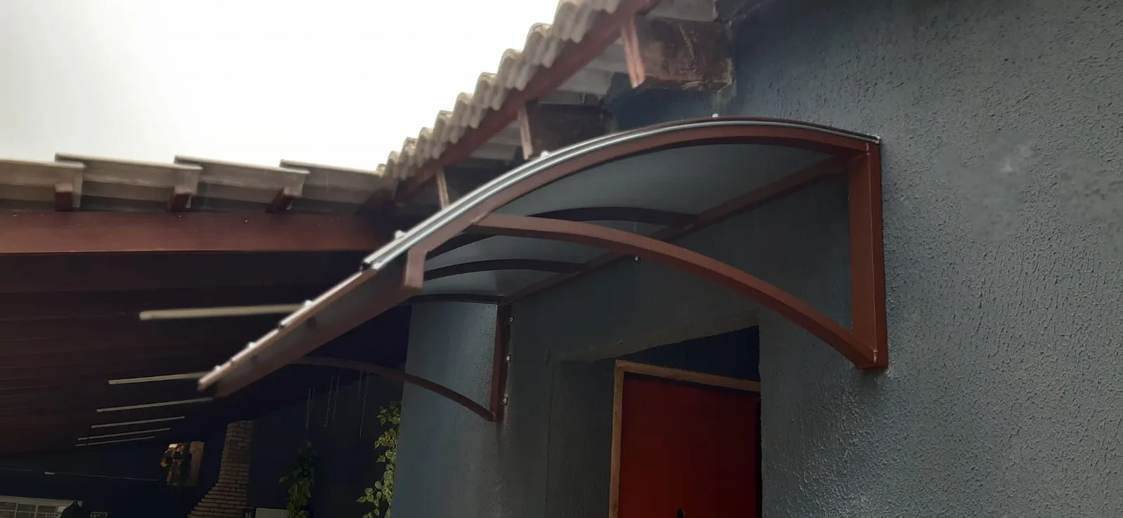 Cobertura de policarbonato cristal sobre entrada com telhado colonial