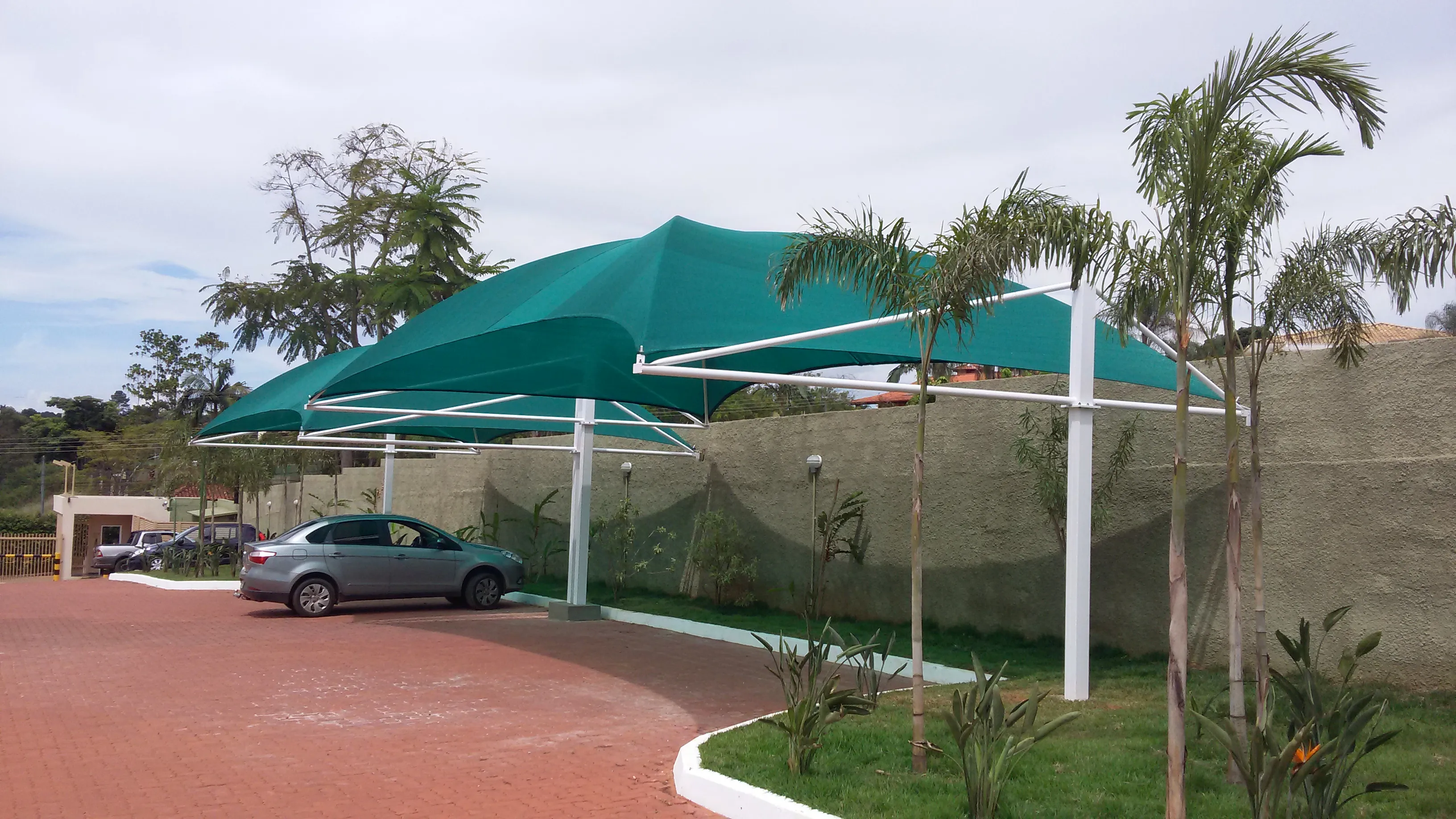 Fileira de sombrites tensionados tipo vela sobre estacionamento