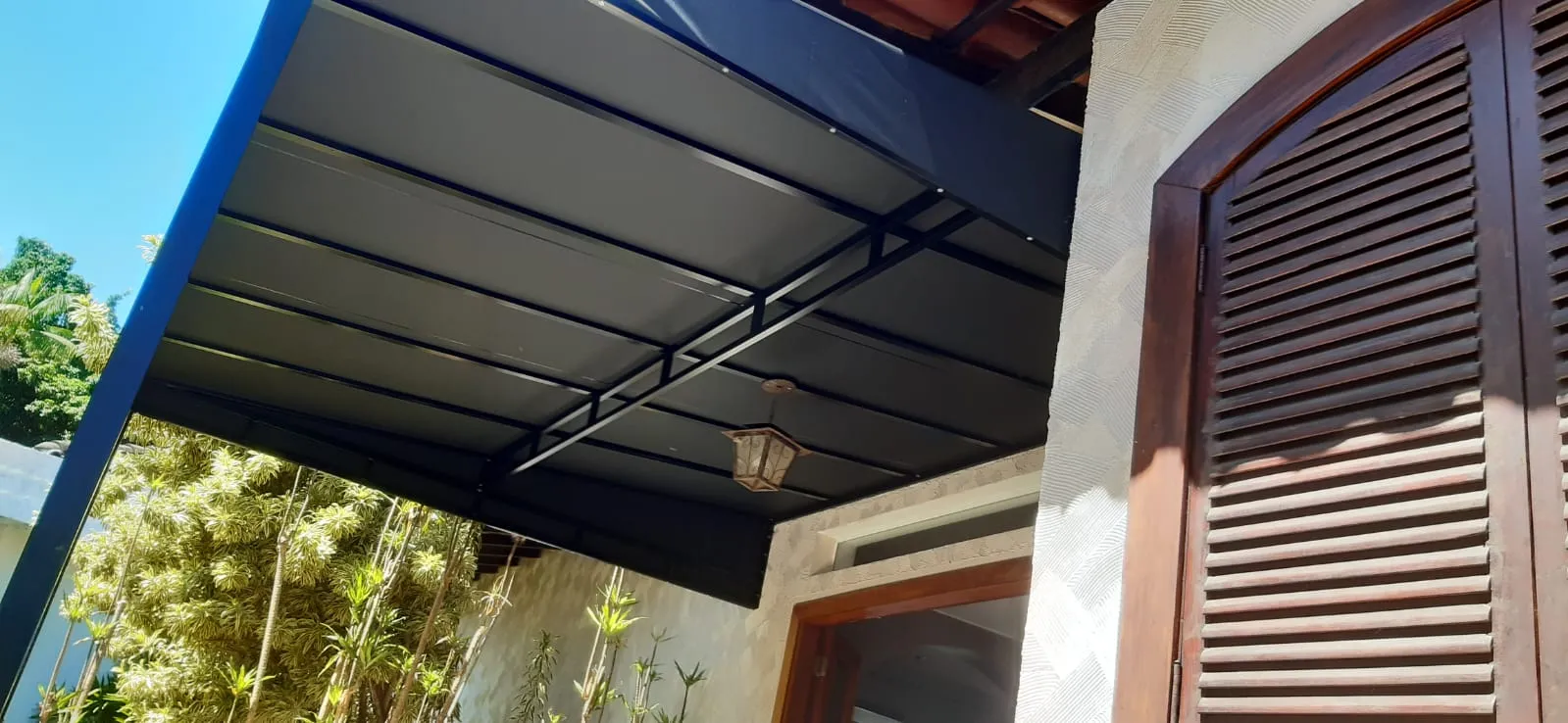 Cobertura fixa em lona azul sobre porta de madeira