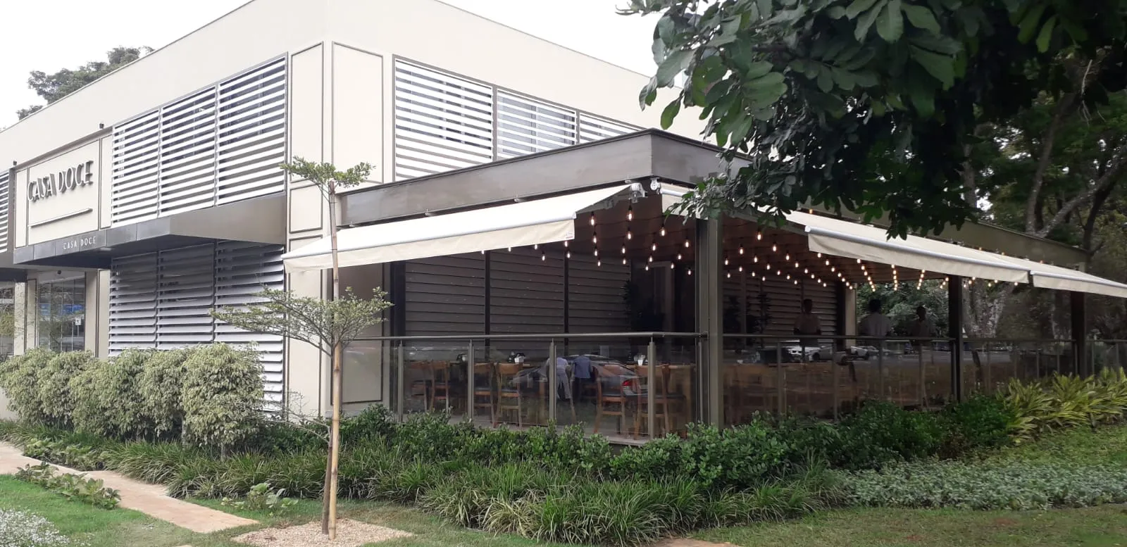 Toldo italiano articulado em restaurante com iluminação noturna