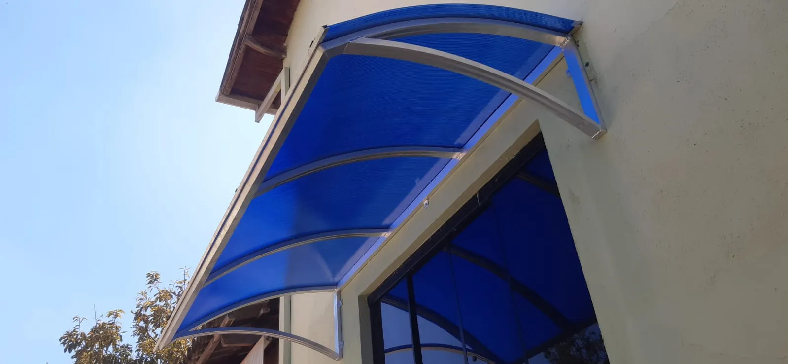 Cobertura de policarbonato azul sobre janela