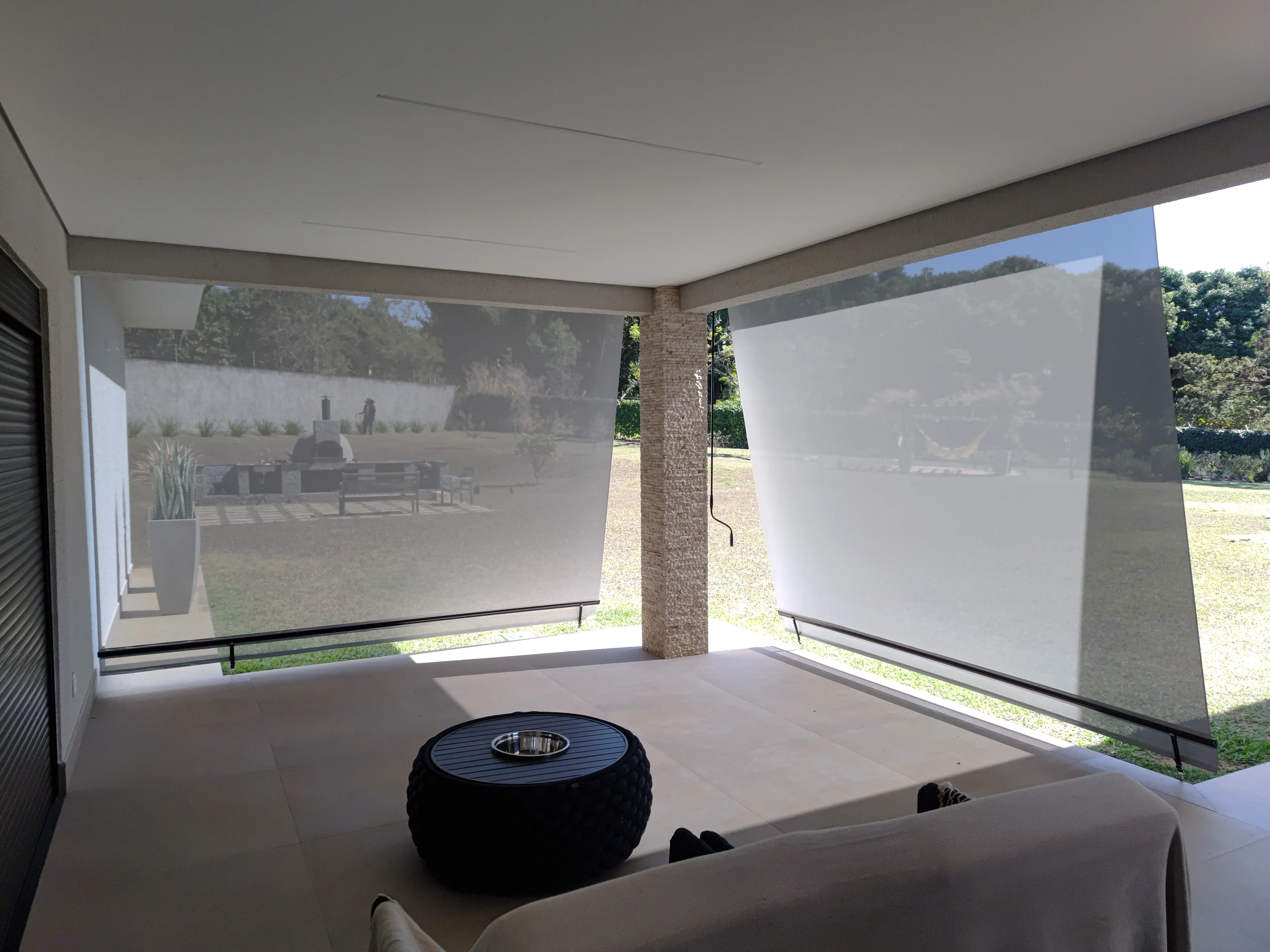 Toldo cortina visto de dentro para fora, com forno de pizza ao fundo
