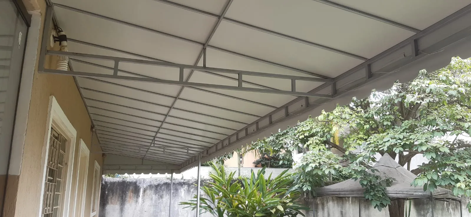 Cobertura fixa em lona cobrindo uma varanda longa