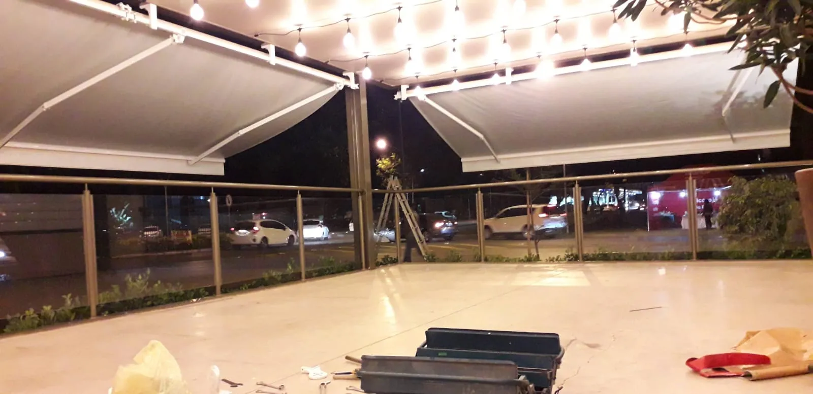 Toldo italiano articulado com iluminação decorativa à noite