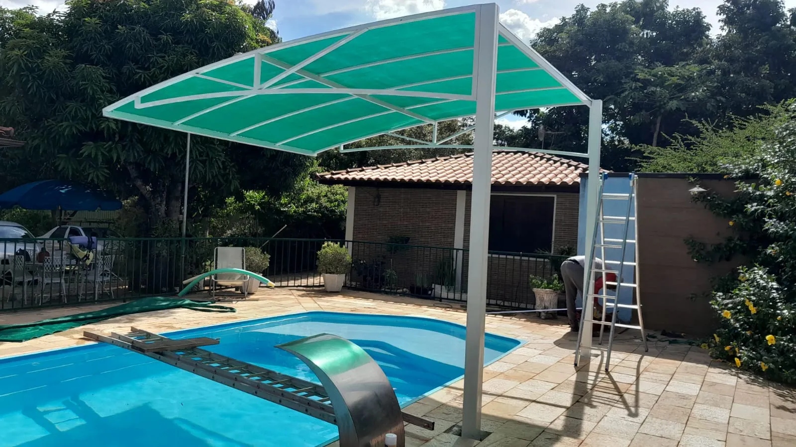 Sombrite piramidal verde sobre área de piscina