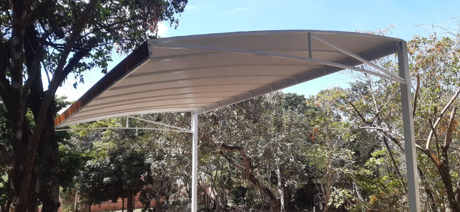 Cobertura fixa em lona curva autoportante entre vegetação