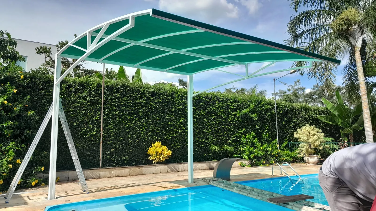 Sombrite curvo verde sobre área de piscina