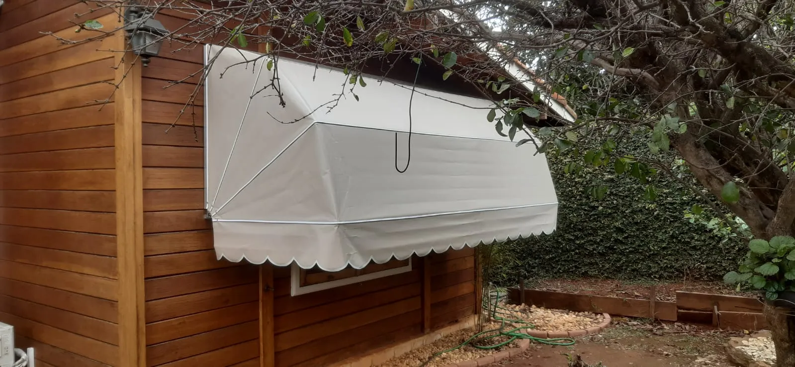 Toldo Mediterrâneo creme em casa de madeira com piscina